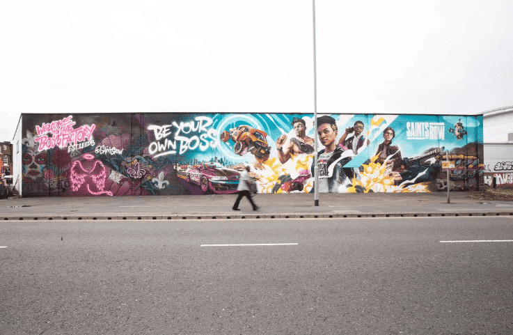 A Man Walking On The Side Of A Road With Graffiti On The Side